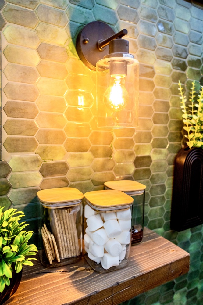 S'mores station detail with marshmallow jars under a warm sconce